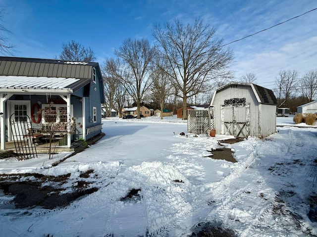 yard layered in snow with an outbuilding and a storage unit