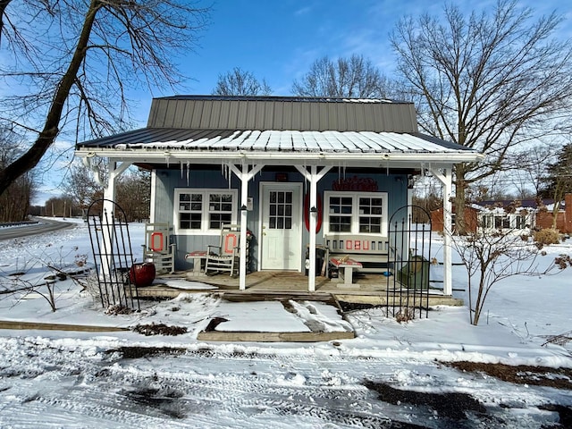 bungalow-style house with an outbuilding, metal roof, and a porch