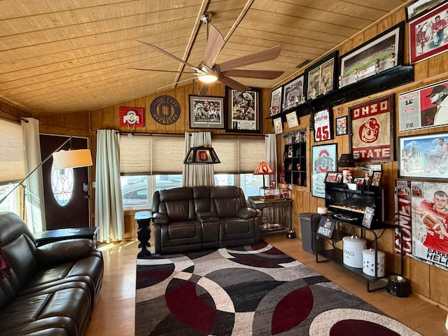 living room with wooden walls, lofted ceiling, wood ceiling, ceiling fan, and wood finished floors