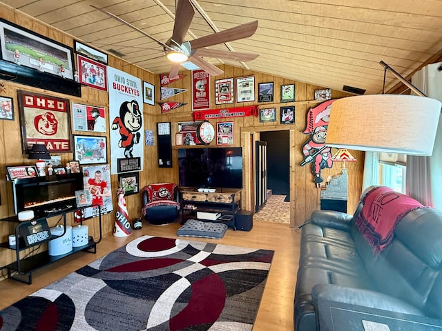 living area with wooden ceiling, wood walls, wood finished floors, a ceiling fan, and vaulted ceiling