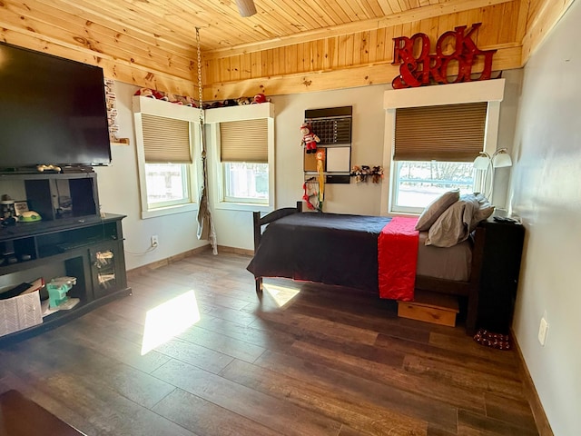 bedroom featuring multiple windows, wooden ceiling, wood finished floors, and baseboards