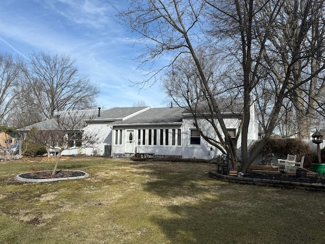 exterior space with a shingled roof and a lawn