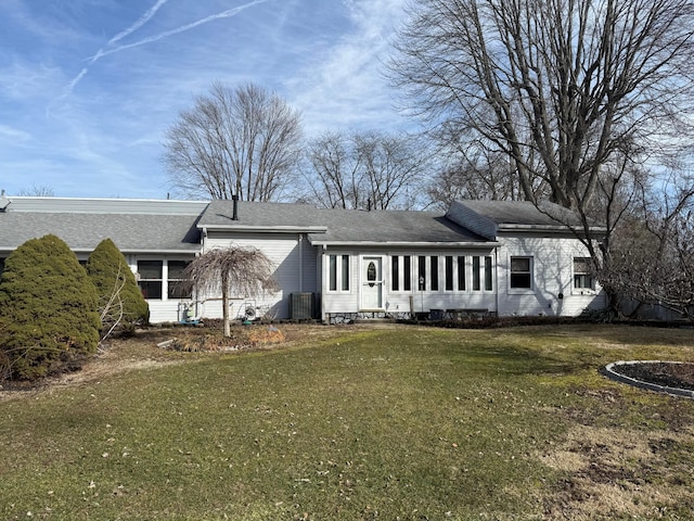 rear view of property featuring a sunroom, central AC, and a yard