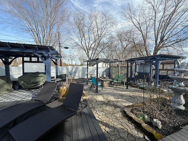 wooden terrace with fence, a fire pit, and a pergola