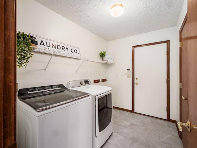 laundry room featuring laundry area, independent washer and dryer, a textured ceiling, and baseboards