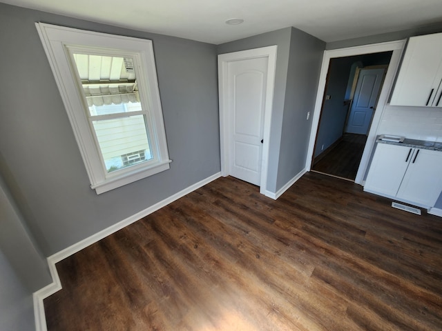 interior space featuring dark wood-type flooring and baseboards