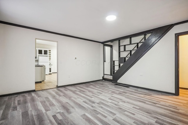 empty room with light wood-type flooring and ornamental molding