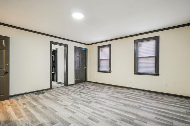 spare room with light hardwood / wood-style flooring and crown molding