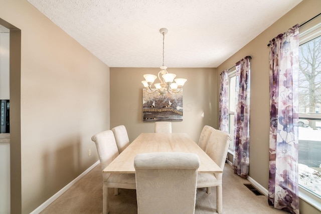 carpeted dining room featuring a textured ceiling and a notable chandelier