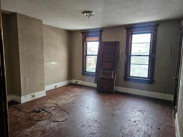 unfurnished room featuring dark hardwood / wood-style floors and a textured ceiling