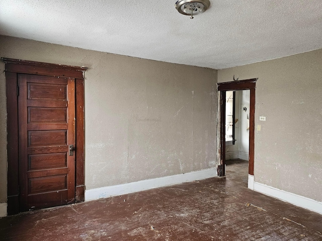 unfurnished room with a textured ceiling