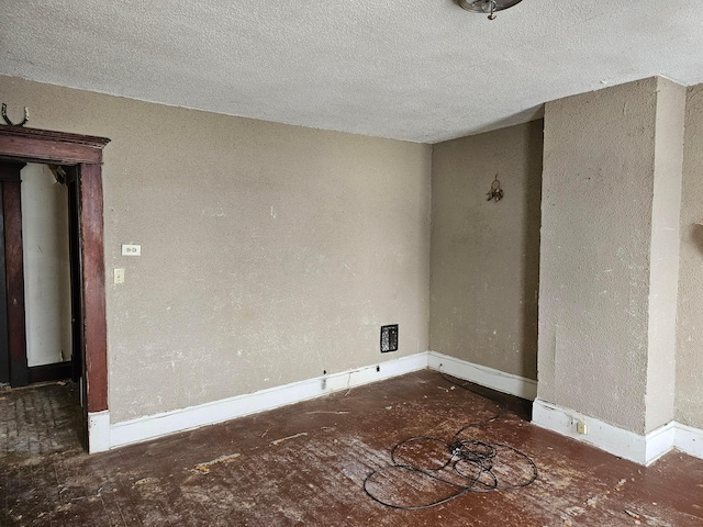 unfurnished room with a textured ceiling