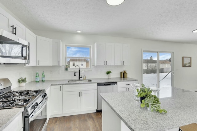 kitchen with a sink, appliances with stainless steel finishes, and white cabinetry