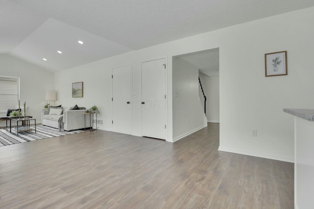 living area featuring vaulted ceiling, baseboards, recessed lighting, and wood finished floors