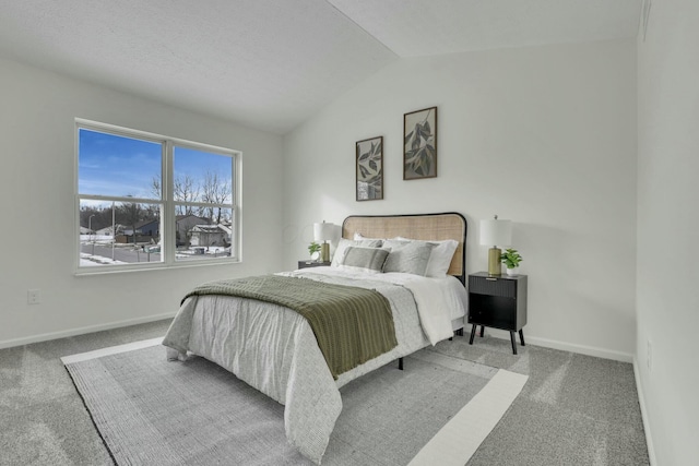 carpeted bedroom featuring baseboards and lofted ceiling