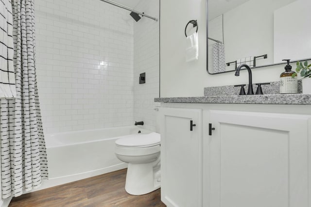 full bathroom with vanity, toilet, wood finished floors, and shower / bath combo