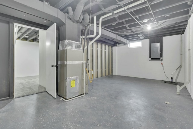 basement featuring concrete block wall and electric panel