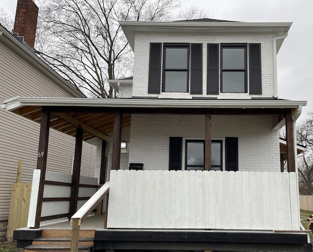 exterior space with covered porch and brick siding