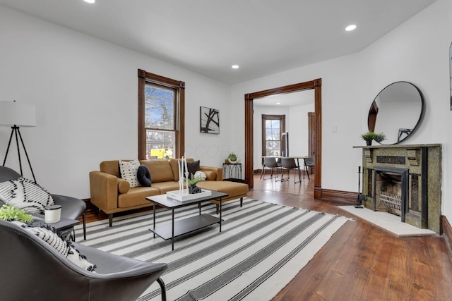 living room with a fireplace, baseboards, wood finished floors, and recessed lighting