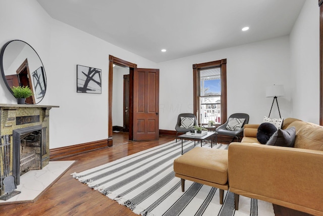 living area with a tile fireplace, recessed lighting, baseboards, and wood finished floors