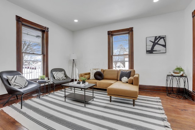 living area featuring baseboards, wood finished floors, a wealth of natural light, and recessed lighting