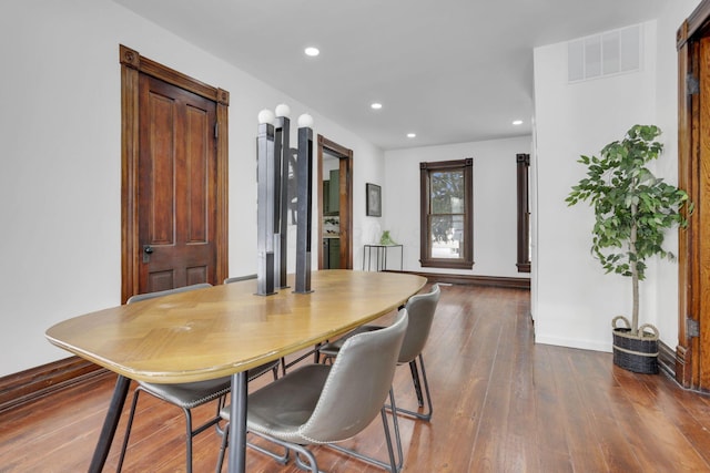 dining space with baseboards, wood finished floors, visible vents, and recessed lighting