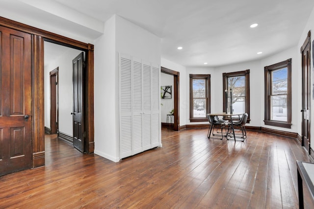 dining area featuring baseboards, wood finished floors, and recessed lighting