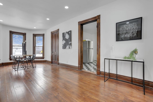 dining space featuring baseboards, wood finished floors, and recessed lighting