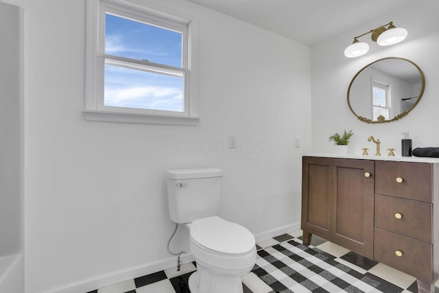 bathroom featuring baseboards, vanity, and toilet