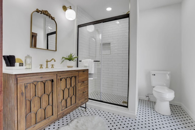 bathroom featuring a stall shower, tile patterned flooring, vanity, and toilet