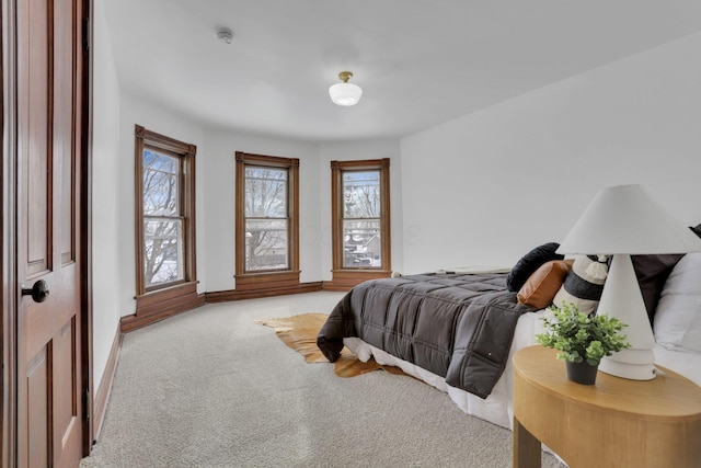 bedroom with light carpet and baseboards