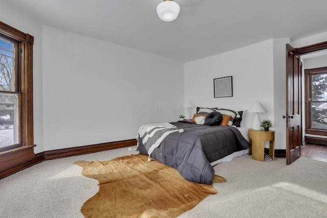 bedroom featuring light colored carpet and baseboards