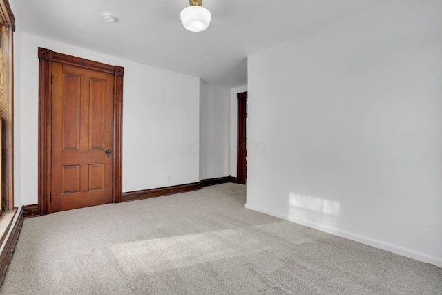 carpeted spare room featuring baseboards