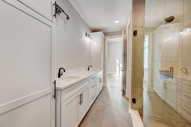 full bathroom with double vanity, tile patterned floors, a sink, and a shower stall