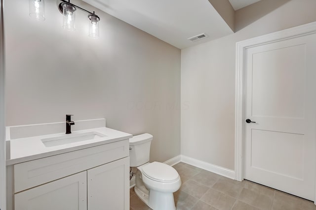 bathroom with tile patterned flooring, toilet, vanity, visible vents, and baseboards