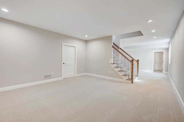 unfurnished room with recessed lighting, light colored carpet, visible vents, stairway, and baseboards