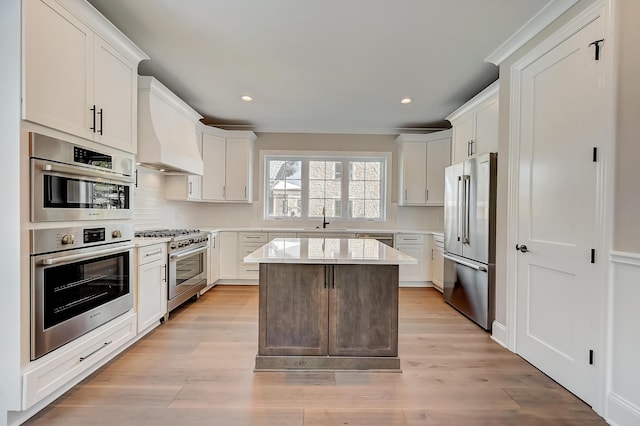 kitchen featuring high end appliances, a center island, custom exhaust hood, light countertops, and a sink