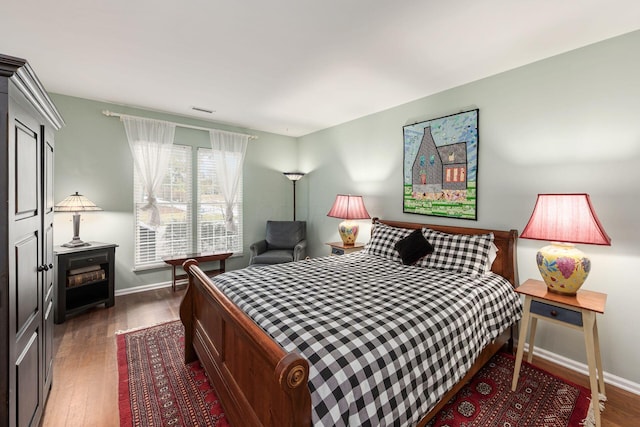 bedroom featuring dark wood-style flooring and baseboards