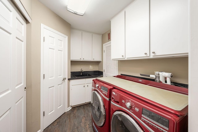 laundry room featuring dark wood-style floors, washing machine and dryer, cabinet space, and a sink