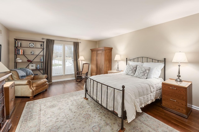 bedroom with dark wood-type flooring and baseboards