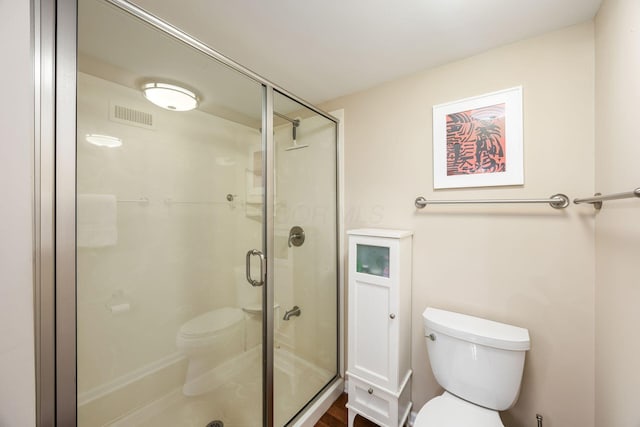 bathroom featuring visible vents, a stall shower, and toilet