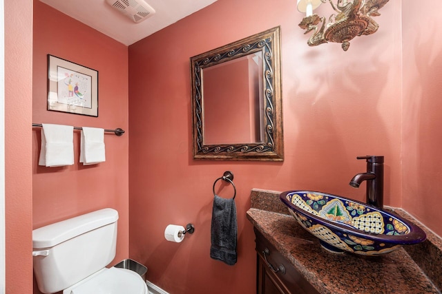 bathroom featuring toilet, visible vents, and vanity