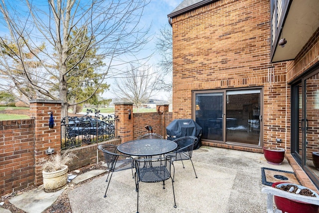 view of patio / terrace with outdoor dining area, fence, and a grill