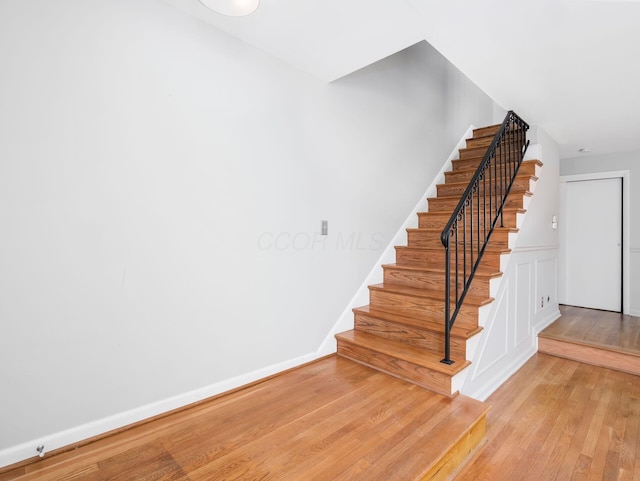 stairway featuring wood finished floors and baseboards