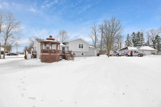 view of front of property featuring a garage, stairway, and a gazebo