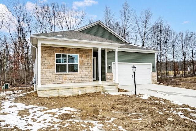 view of front of house featuring a shingled roof, concrete driveway, stone siding, and a garage