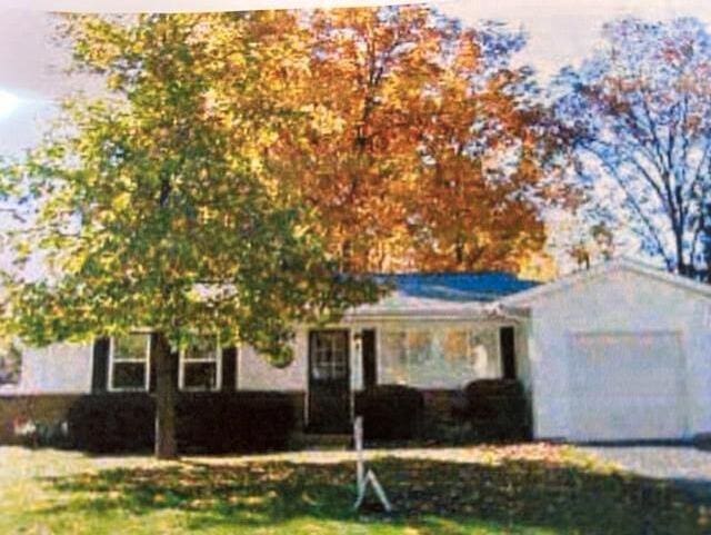 ranch-style house with an attached garage and a front yard