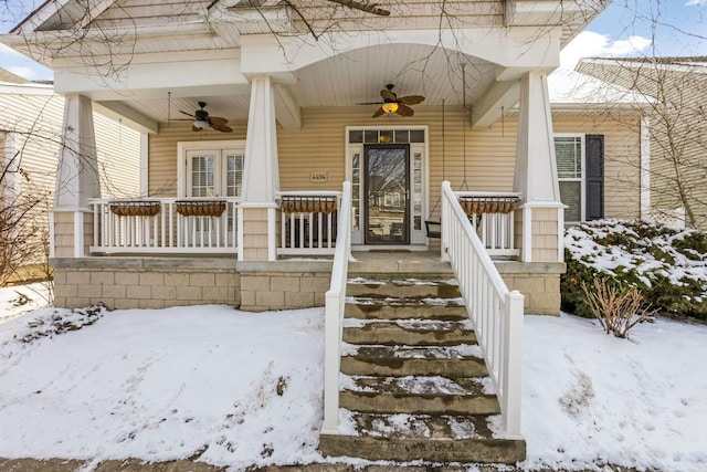 snow covered property entrance featuring a porch and ceiling fan