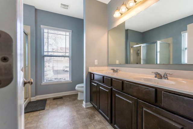 full bath with double vanity, baseboards, visible vents, and a sink