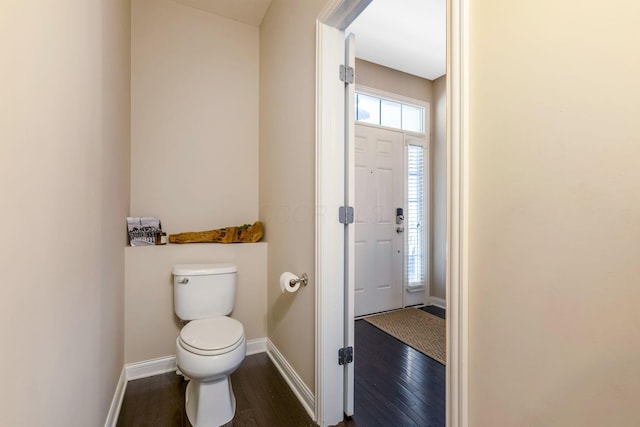 bathroom with baseboards, toilet, and wood finished floors